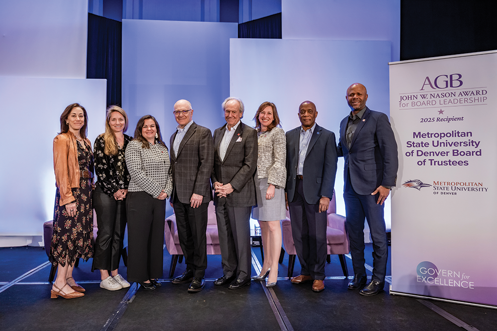 A group of eight people stand in a row at an award ceremony. From left to right: President Janine Davidson, Rachel Kaygi, Olivia Mendoza, David Fine (general counsel and secretary to the board), Jerry Glick (vice chair), Kristin Hultquist (chair), Russell Notes (past chair), and Ryan Frazier. They are positioned in front of a banner that reads 'AGB JOHN W. NASON AWARD for BOARD LEADERSHIP' and '2025 Recipient Metropolitan State University of Denver Board of Trustees' with the university's logo. The setting features blue-lit backdrops and light-colored chairs are visible in the background. The banner displays 'GOVERN for EXCELLENCE' at the bottom.